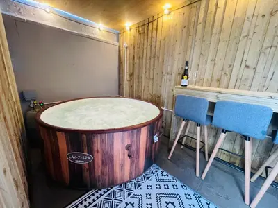 a tub in a room with a table and chairs at Osborne hot tub and jacuzzi suites in Blackpool