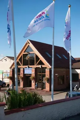 two flags are flying in front of a building at 2 Bed - Sleeps 6 - 15min Walk to Beach in Morecambe