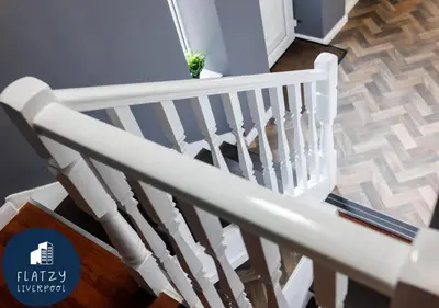 a white rail on a staircase in a house at FLATZY - 6 bed Oasis Close to Football Stadiums in Liverpool