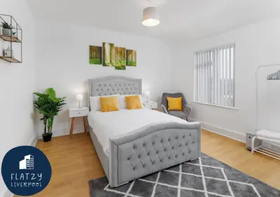 a bedroom with a large white bed with orange pillows at FLATZY - 6 bed Oasis Close to Football Stadiums in Liverpool