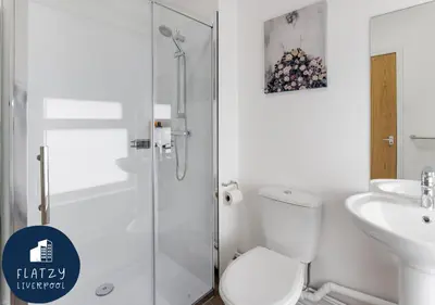 a bathroom with a shower and a toilet and a sink at FLATZY - 6 bed Oasis Close to Football Stadiums in Liverpool