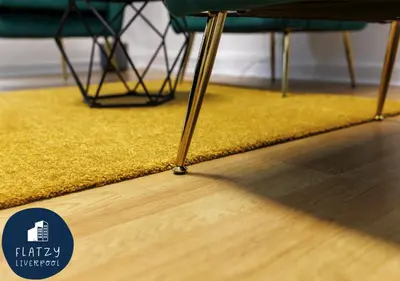 a yellow rug on a floor with a table and chairs at FLATZY - 6 bed Oasis Close to Football Stadiums in Liverpool