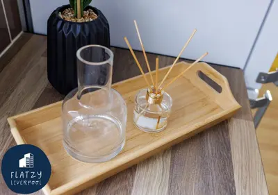 two glass vases on a wooden tray with a vase at FLATZY - 6 bed Oasis Close to Football Stadiums in Liverpool