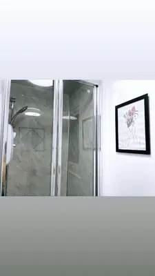 a shower in a bathroom with a picture on the wall at Ivy Chic Apartments by CityNest in Blackpool