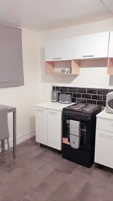 a kitchen with a black stove and white cabinets at Ivy Chic Apartments by CityNest in Blackpool