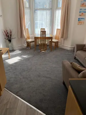 a living room with a table and chairs at Delamere ground floor holiday flat in Blackpool