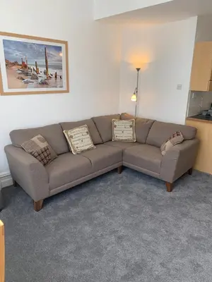 a living room with a brown couch in a room at Delamere ground floor holiday flat in Blackpool