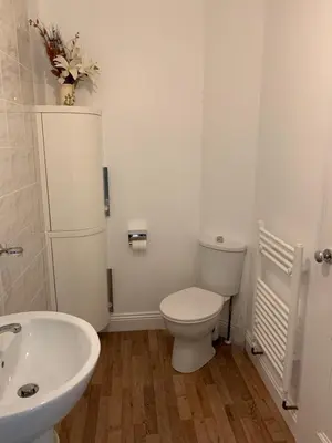 a white bathroom with a toilet and a sink at Delamere ground floor holiday flat in Blackpool