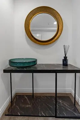 a table with a mirror on a wall at Mode Apartments Winter Gardens Blackpool in Blackpool