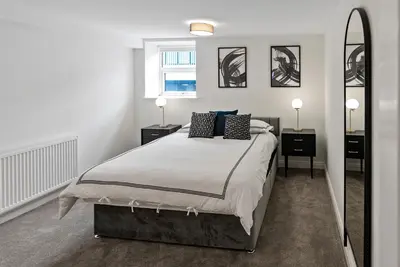 a bedroom with a large bed and a mirror at Mode Apartments Winter Gardens Blackpool in Blackpool