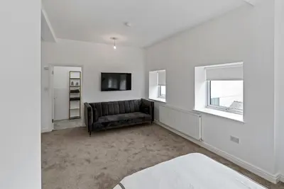a living room with a couch and a television at Mode Apartments Winter Gardens Blackpool in Blackpool