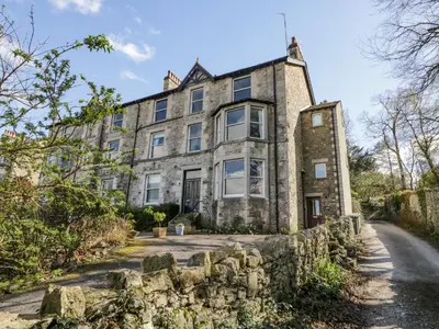 an old stone house with a stone wall at Crow's Nest in Carnforth