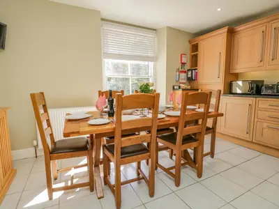 a kitchen with a wooden dining room table and chairs at Crow's Nest in Carnforth