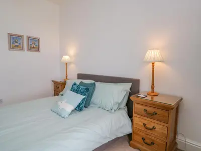 a bedroom with a bed with two lamps and a dresser at Crow's Nest in Carnforth