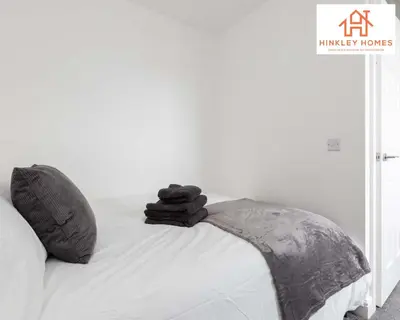 a bed with black towels sitting on top of it at Modern Townhouse - Free Gated Parking - City Centre - 5 ! By Hinkley Homes Short Lets & Serviced Accommodation in Liverpool