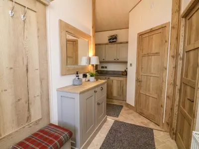 a kitchen with wooden doors and a counter in a room at Curlew Lodge in Carnforth