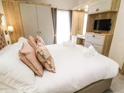 a bedroom with a large white bed with pillows at Curlew Lodge in Carnforth