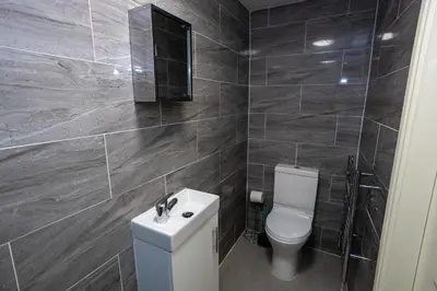 a bathroom with a white toilet and a mirror at TCO Luxury House in Liverpool