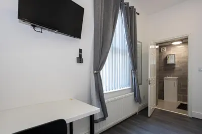 a room with a desk and a television on a wall at TCO Luxury House in Liverpool