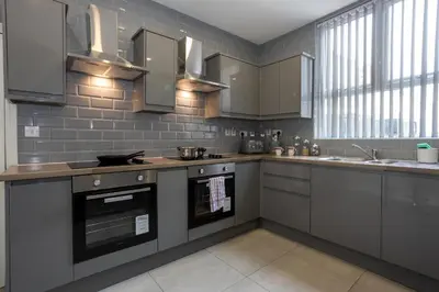 a kitchen with gray cabinets and stainless steel appliances at TCO Luxury House in Liverpool