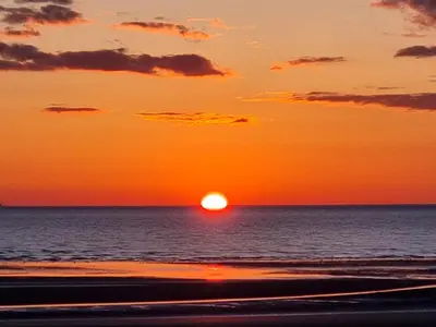 a sunset over the ocean with the sun in the sky at Granada Apartments Derby Road in Blackpool