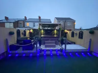 a backyard with blue lights and a patio at NEW…THE HOTTUB HOUSE BLACKPOOL PLEASURE BEACH in Blackpool
