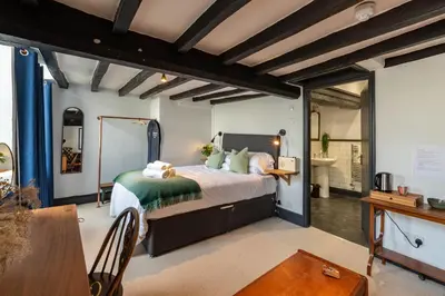 a bedroom with a large bed and a table at Royal Oak Pub in Cartmel
