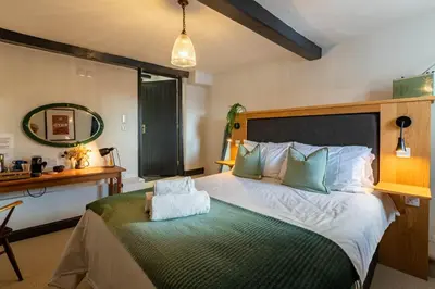 a bedroom with a large bed and a desk at Royal Oak Pub in Cartmel