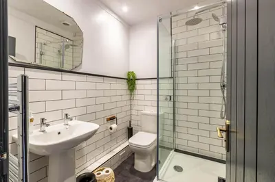 a bathroom with a sink and a toilet and a mirror at Royal Oak Pub in Cartmel