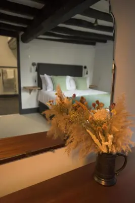 a vase of flowers sitting on a table in front of a mirror at Royal Oak Pub in Cartmel