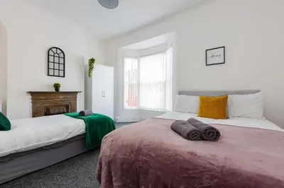a bedroom with two beds and a fireplace at 4-Bedroom House sleeps 9 in Liverpool Perfect for Contractors - Free Parking - Fast WiFi - Fully Equipped Kitchen - Hosted by By Hinkley Homes Short Lets & Serviced Accommodation in Liverpool