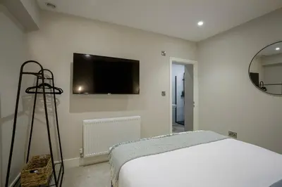 a bedroom with a bed and a tv on the wall at Five Apartments in Blackpool