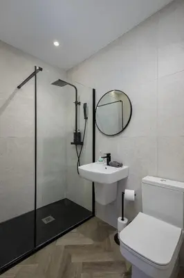 a bathroom with a toilet and a sink and a mirror at Five Apartments in Blackpool