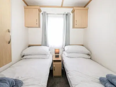 two beds in a small room with a window at The Maples in Millom