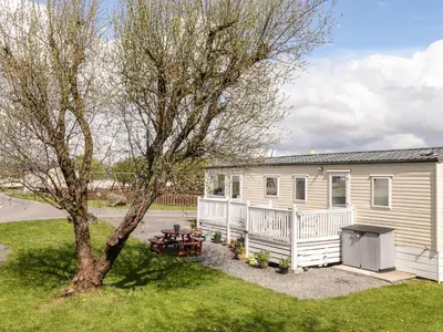 a house with a picnic table and a tree at The Maples in Millom