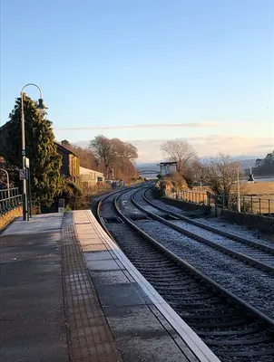 a set of train tracks next to a train station at SANDYVIEWS in Grange Over Sands