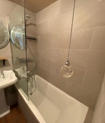 a bathroom with a bath tub and a sink at SANDYVIEWS in Grange Over Sands