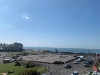 a highway with cars parked in a parking lot next to the ocean at Willshaw Suites for families over 25 only in Blackpool