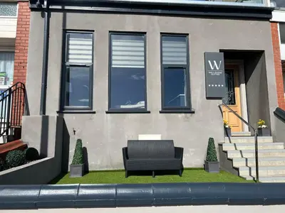 a black couch sitting in front of a building at Willshaw Suites for families over 25 only in Blackpool