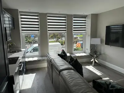 a living room with a couch and two windows at Willshaw Suites for families over 25 only in Blackpool