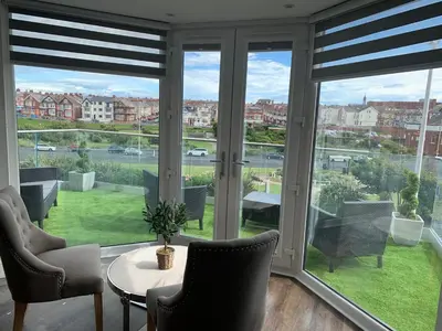 a room with large windows with chairs and a table at Willshaw Suites for families over 25 only in Blackpool