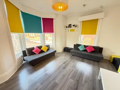 a living room with two couches with colorful pillows at Deco apartment 5 min walk from Blackpool tower sleeps 12 in Blackpool