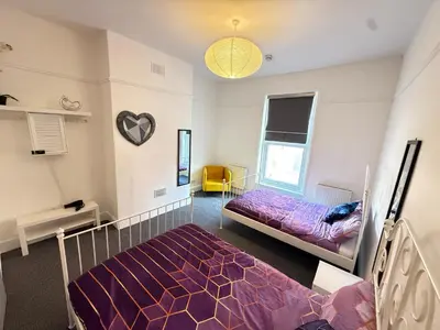 a bedroom with two beds and a window at Deco apartment 5 min walk from Blackpool tower sleeps 12 in Blackpool