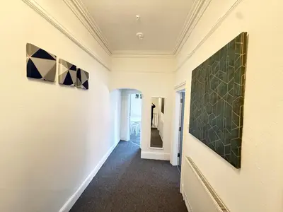 a hallway with two paintings on the walls at Deco apartment 5 min walk from Blackpool tower sleeps 12 in Blackpool