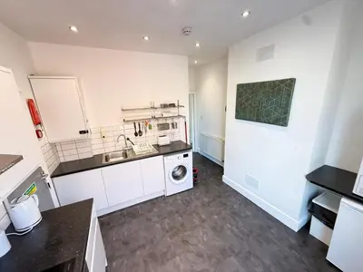 a kitchen with a sink and a washing machine at Deco apartment 5 min walk from Blackpool tower sleeps 12 in Blackpool
