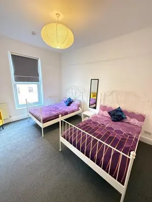 a bedroom with two beds and a chandelier at Deco apartment 5 min walk from Blackpool tower sleeps 12 in Blackpool