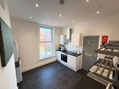 a small kitchen with a stove and a window at Deco apartment 5 min walk from Blackpool tower sleeps 12 in Blackpool