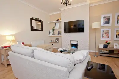 a living room with a white couch and a tv at Anfield Apartment in Liverpool