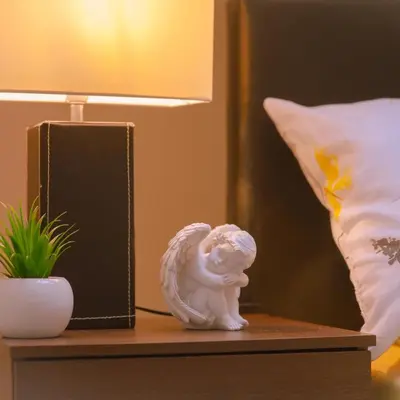 a statue of an angel sitting on a table next to a lamp at Anfield Apartment in Liverpool