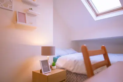 a bedroom with a bed and a table with a lamp at Anfield Apartment in Liverpool